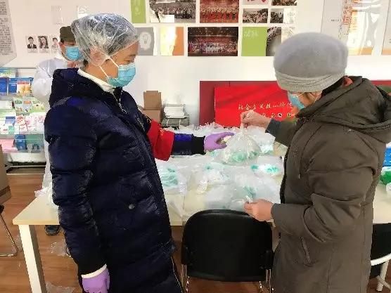 為樓棟分發(fā)口罩，并為包裝袋消毒